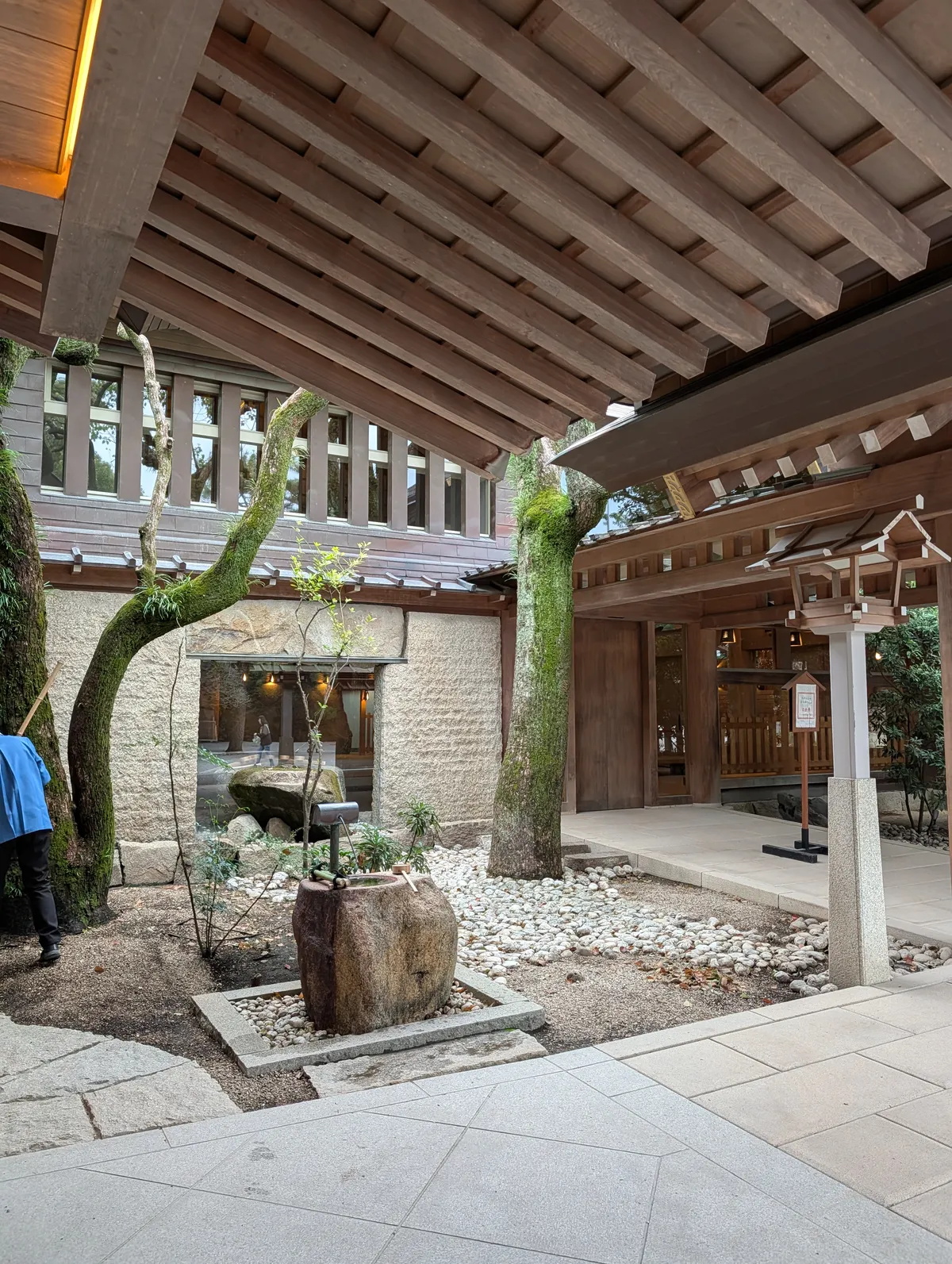 Moss-covered trees and temizuya purification basin in a tranquil courtyard at Atsuta Shrine