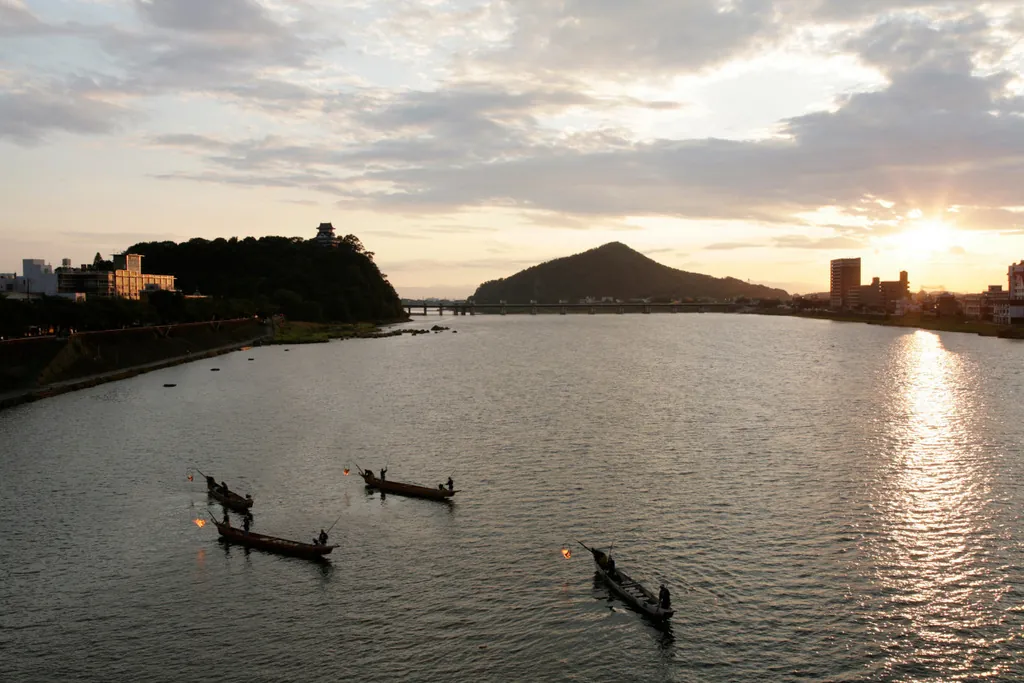 Cormorant fishing boats with flaming bonfires on the Kiso River below Inuyama Castle at night