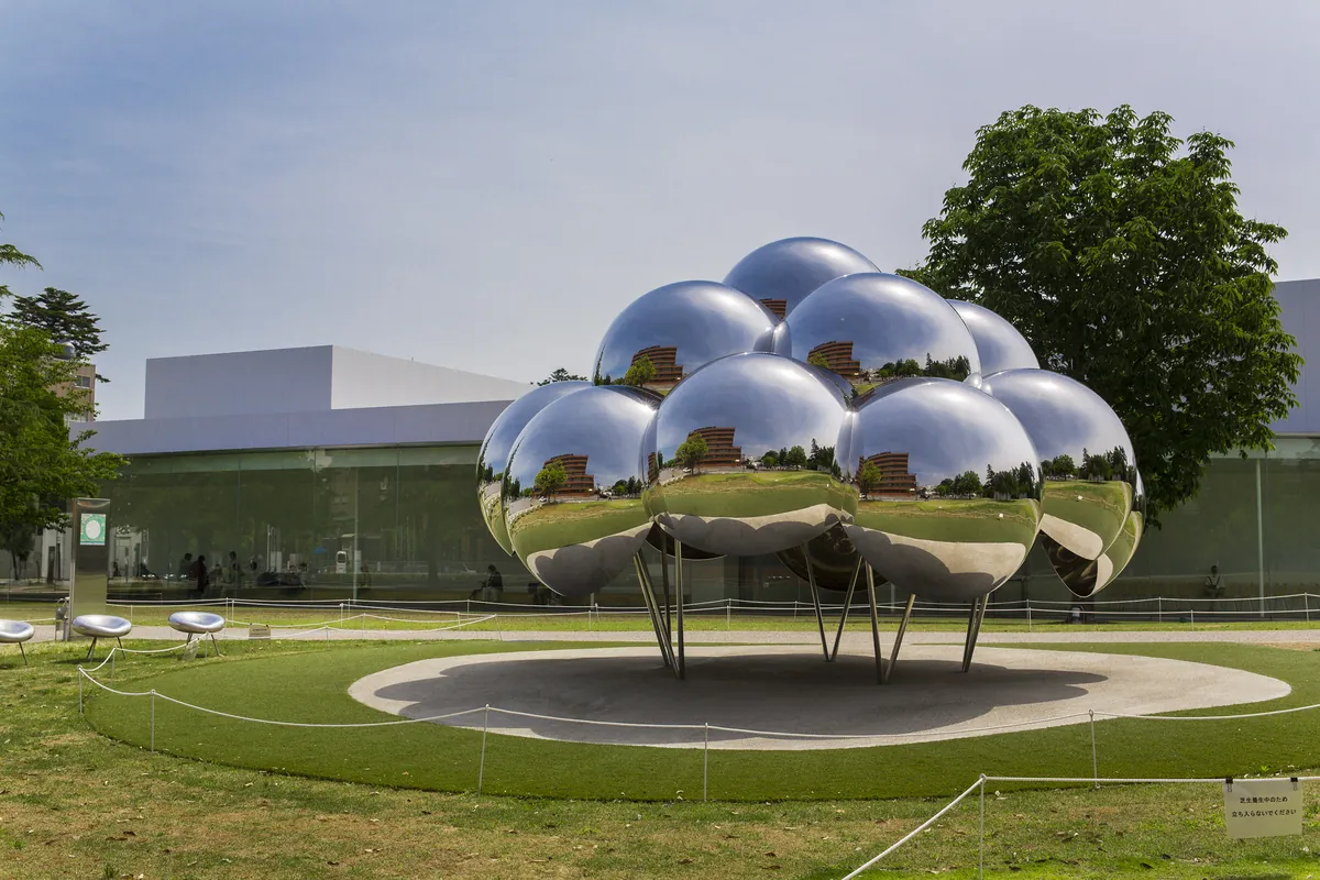 Mirror-sphere outdoor sculpture reflecting the museum's glass architecture