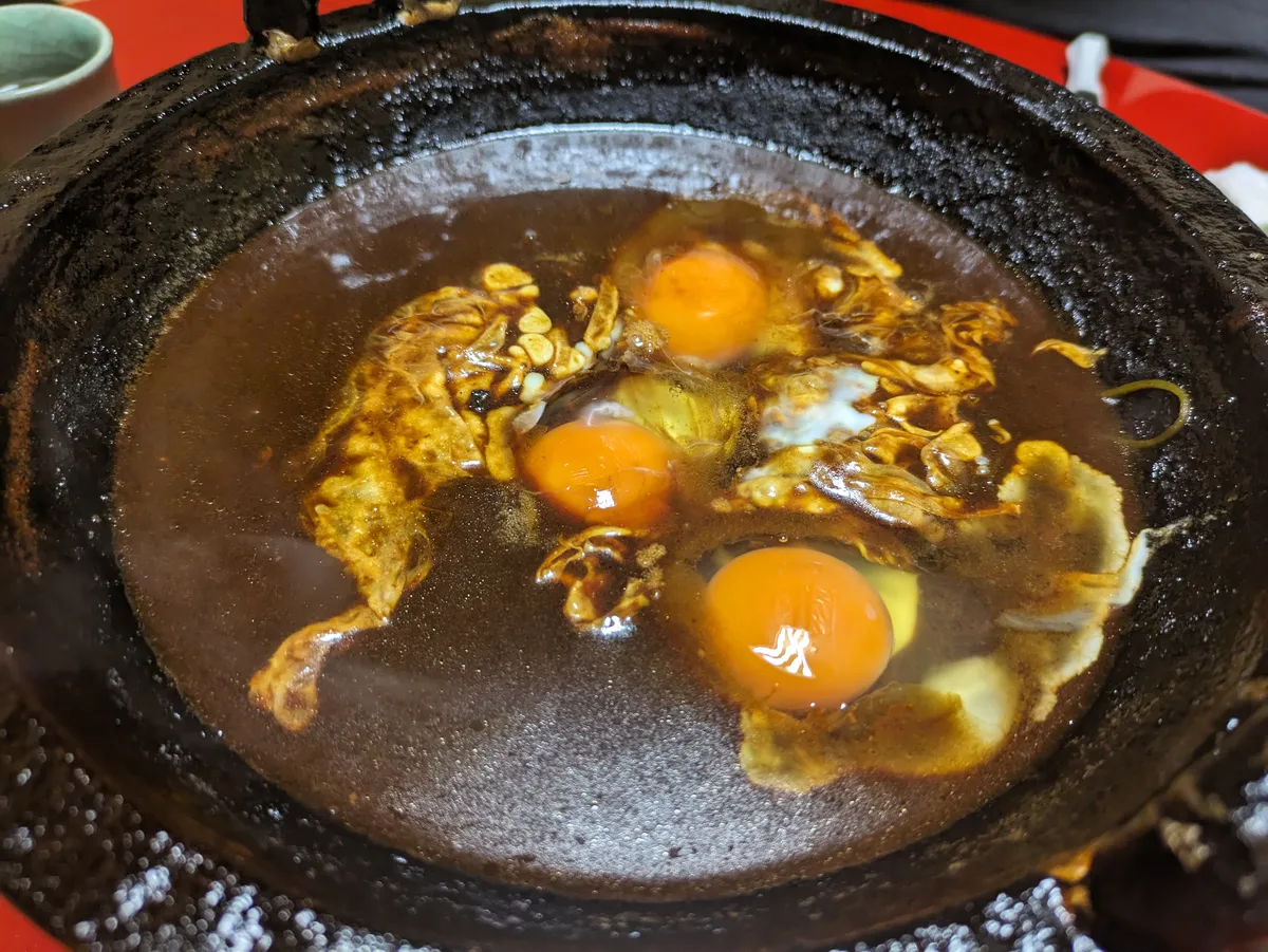 Tori no miso nabe cooking at the table with eggs in rich miso broth