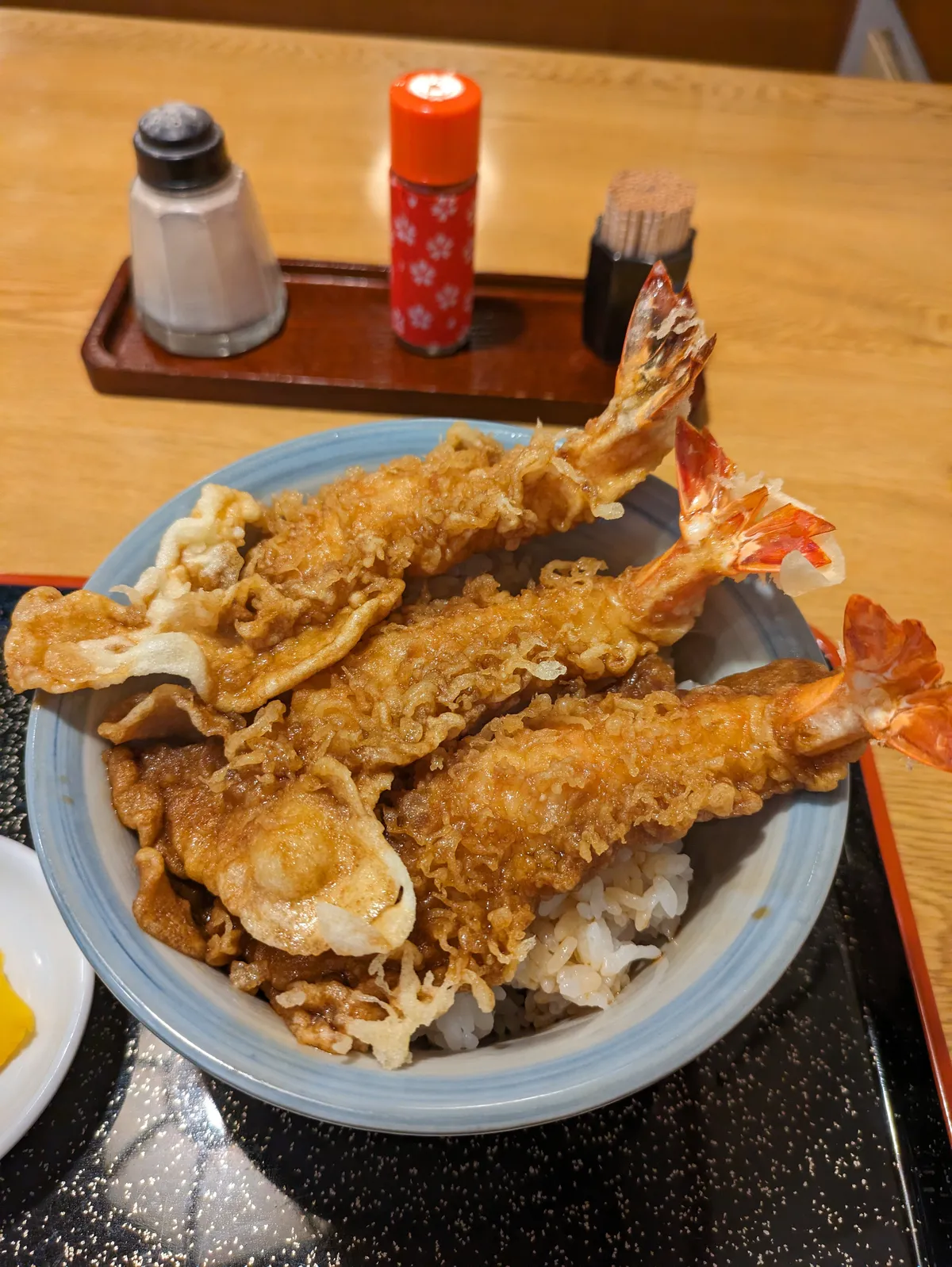Jumbo tempura rice bowl overflowing with crispy shrimp and vegetables at an Osu restaurant