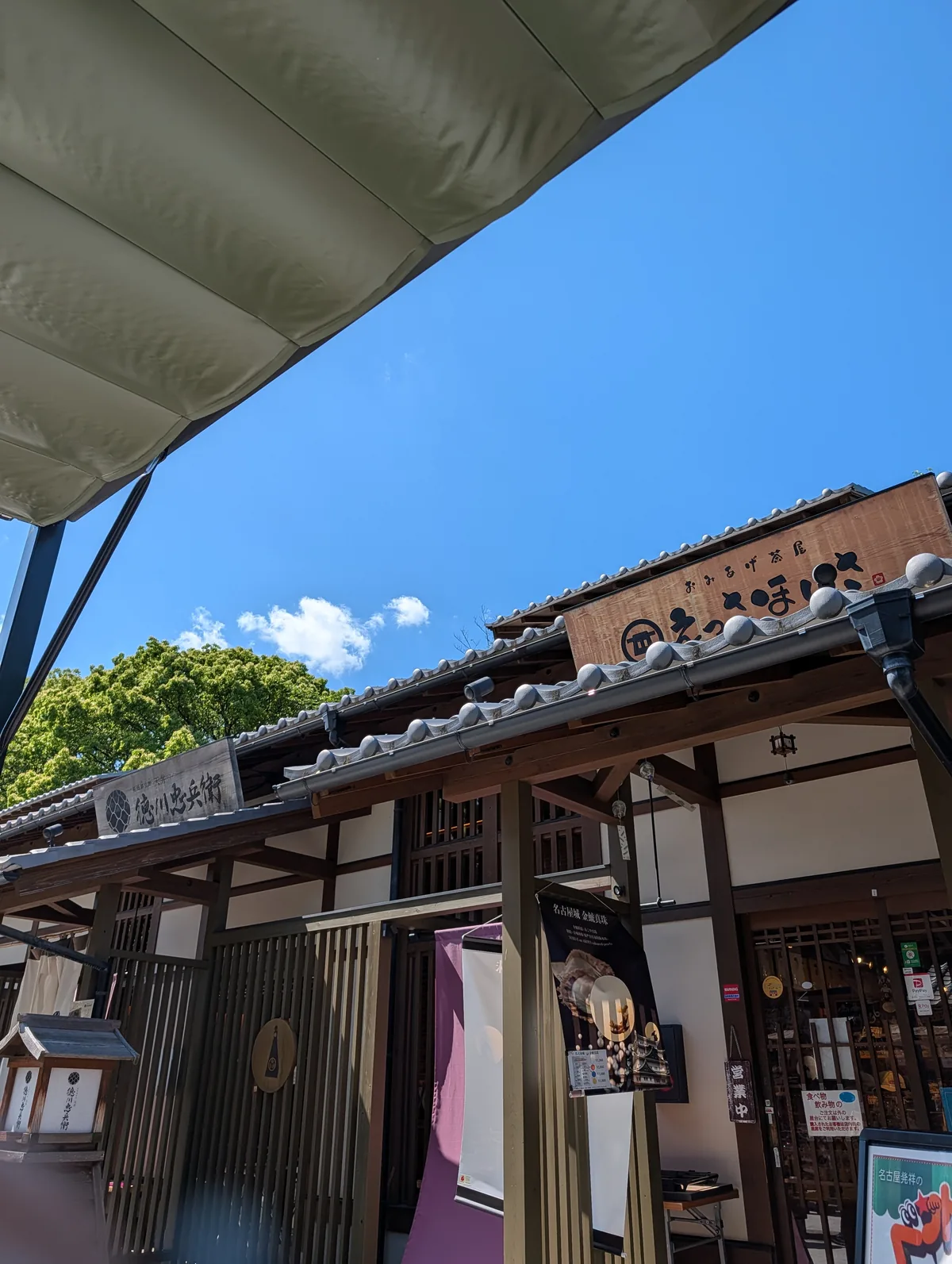 Storefront of Tokugawa Chubei in the Yoshinao Zone of Kinshachi Yokocho, with a tile roof and the bright blue sky above