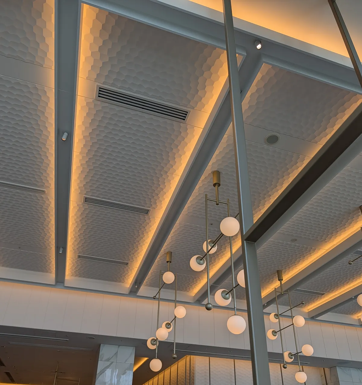 Interior of CRUST all-day dining at Courtyard by Marriott Nagoya, showing the buffet counters below a honeycomb-patterned ceiling