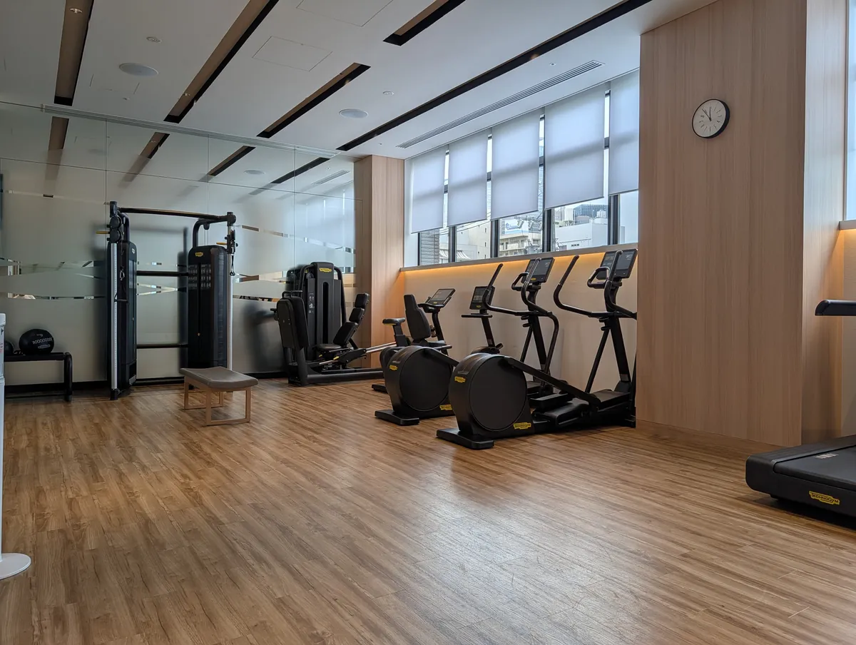 The empty second-floor fitness centre at Courtyard by Marriott Nagoya, with rows of new Technogym cardio machines and daylight through the windows
