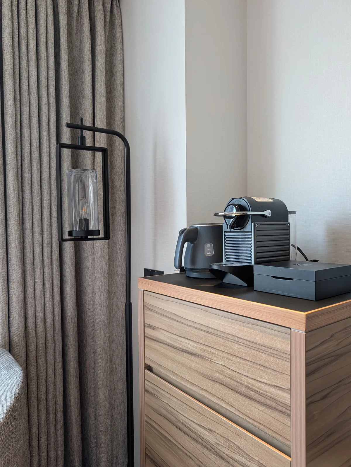 A guest room corner at Courtyard by Marriott Nagoya with a Nespresso machine, an electric kettle and a table lamp on a dark wooden counter