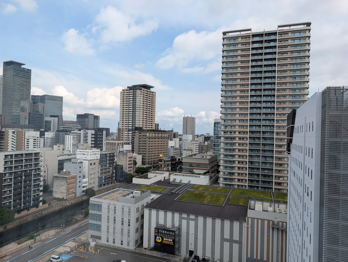 View from a twelfth-floor room at Courtyard by Marriott Nagoya on a clear day, looking towards the Nagoya Station high-rise cluster with the Horikawa river below