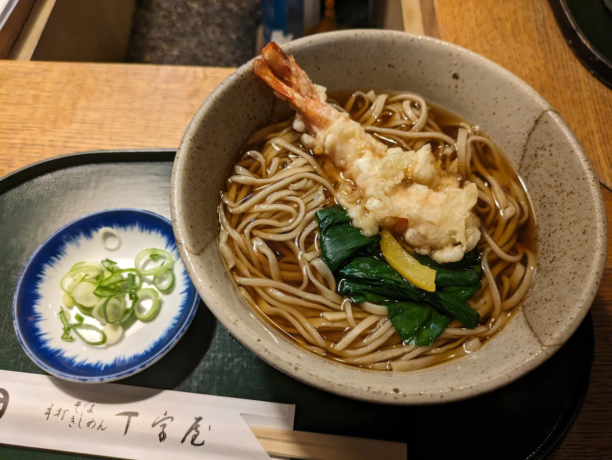 A bowl of hot soba topped with shrimp tempura and greens at a soba shop in the Osu district of Nagoya